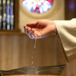 water dripping from pastor's hand