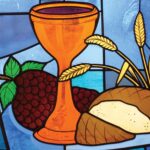 Stained glass of a copper-colored chalice filled with wine, a loaf of bread, a bunch of grapes, and stalks of wheat on a blue background